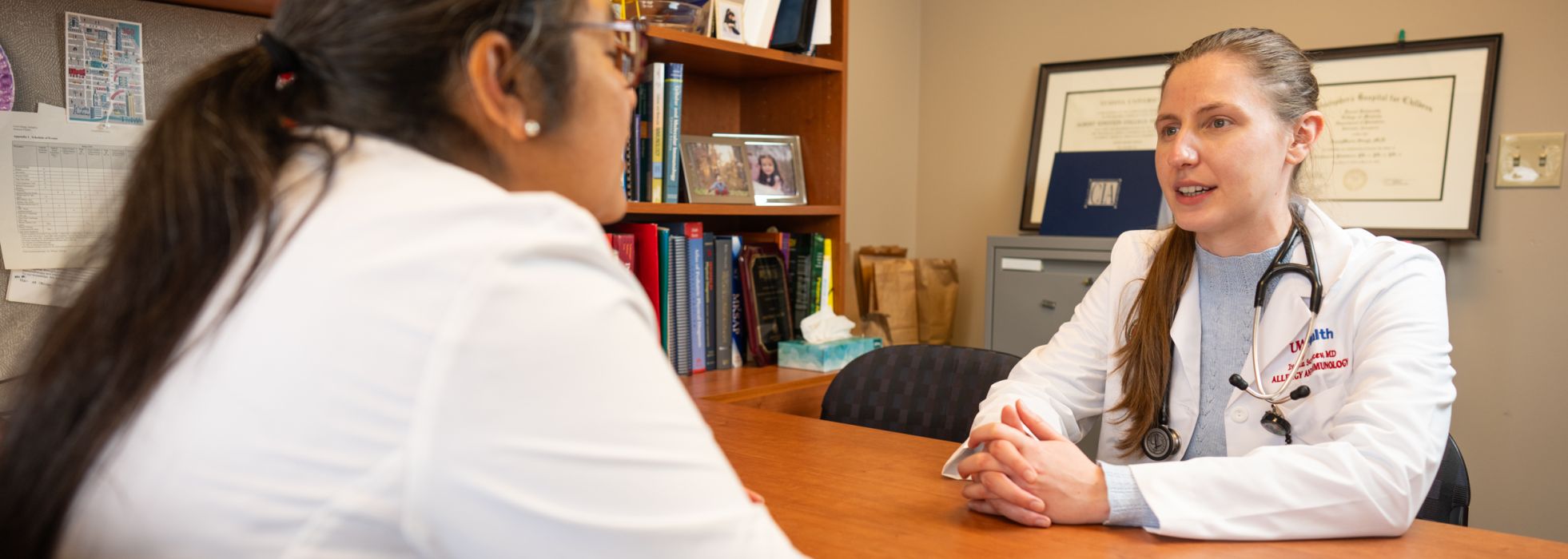 photo of Dr. Anne Marie Singh talking to fellow at desk 