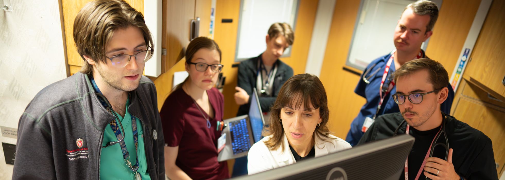 A doctor and residents gathered around a computer screen