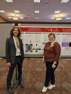 Drs. Bruin Armwald and Jennifer Woodard standing in front of a research poster presentation.