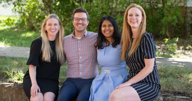 Photo of the 2023-2024 chief residents sitting in a row on a low wall outside
