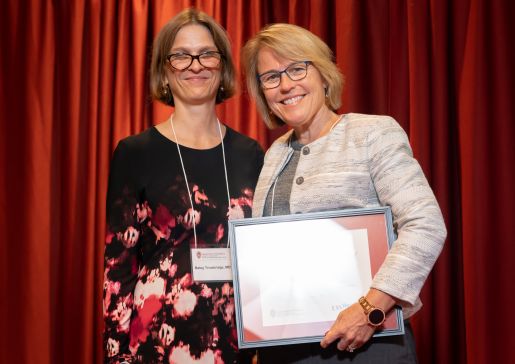 Dr. Betsy Trowbridge and Dr. Ann Schmidt in front of red curtain at a Department of Medicine awards ceremony