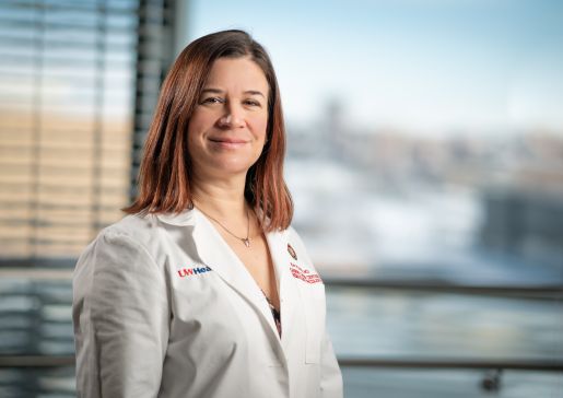 Kari Wisinski, MD, stands wearing a white coat