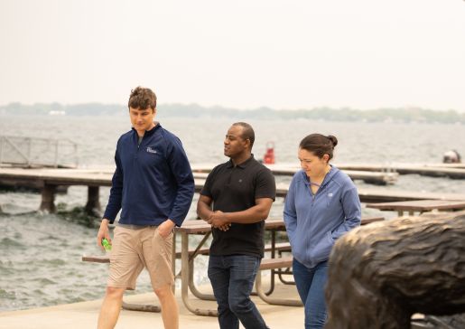 Graduating 2024 internal medicine residents Zak Scherzer, MD, Habib Kedir, MD, and Alaina Kelly, MD, enjoy a walk by Lake Mendota.