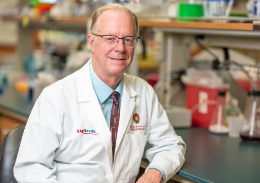 Dr. Allan Brasier in a white lab coat in his lab