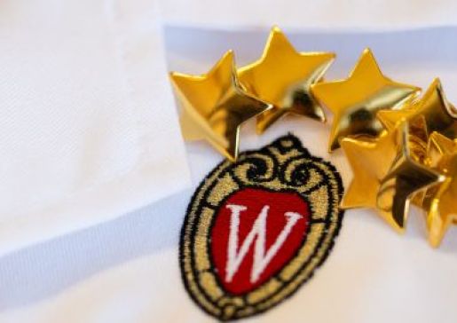 Star pins on a white doctor's coat with the UW crest