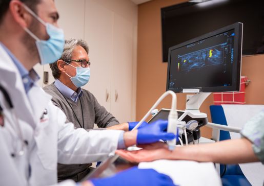Doctors performing an ultrasound on a patient's wrist