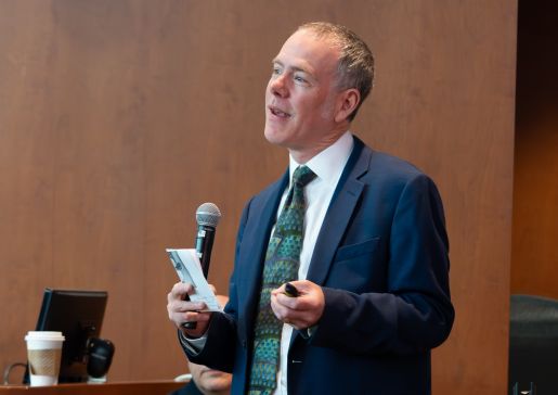 Loren Denlinger holding a microphone and speaking